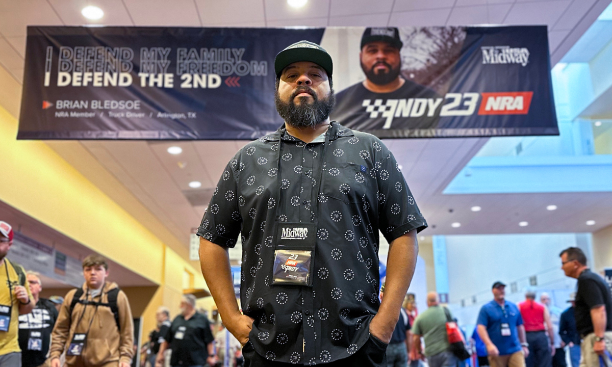NRA members were featured prominently in the show signage like Mr. Brian Bledsoe, a truck driver from Arlington Texas seen here standing in front of his banner