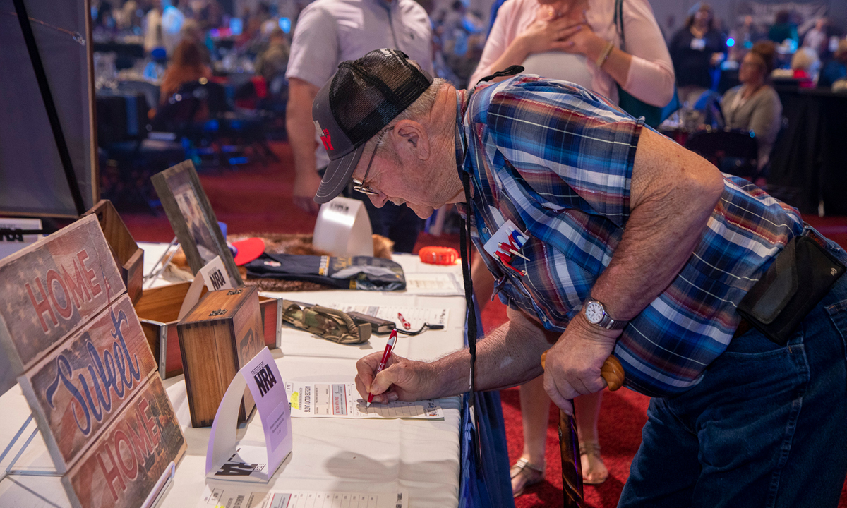 A man bids on a silent auction at the NRA F oundation Banquet and Auction